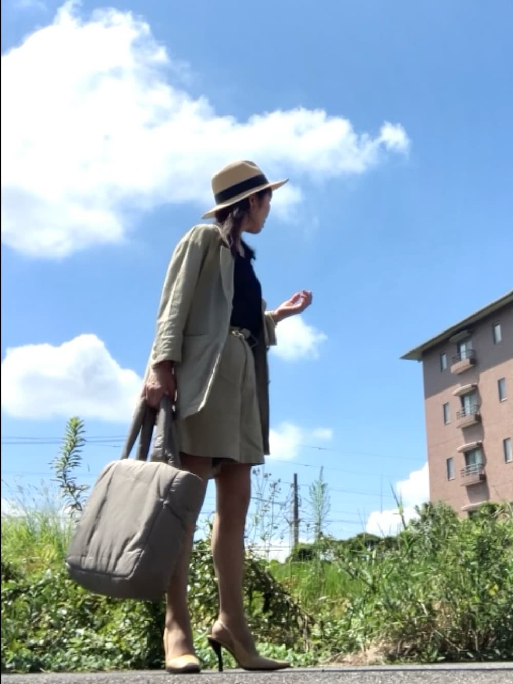 ベージュ系のテーラードジャケット、ベージュ系のパンツ、ブラック系のタンクトップを着用したレディースの夏コーディネートの2枚目の写真