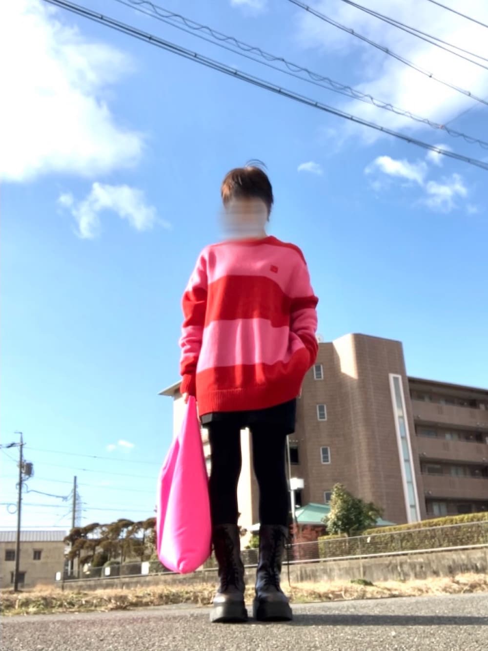 レッド系のニット/セーター、ブラック系のパンツ、ブラック系のハンドバッグを着用したレディースの冬コーディネートの2枚目の写真