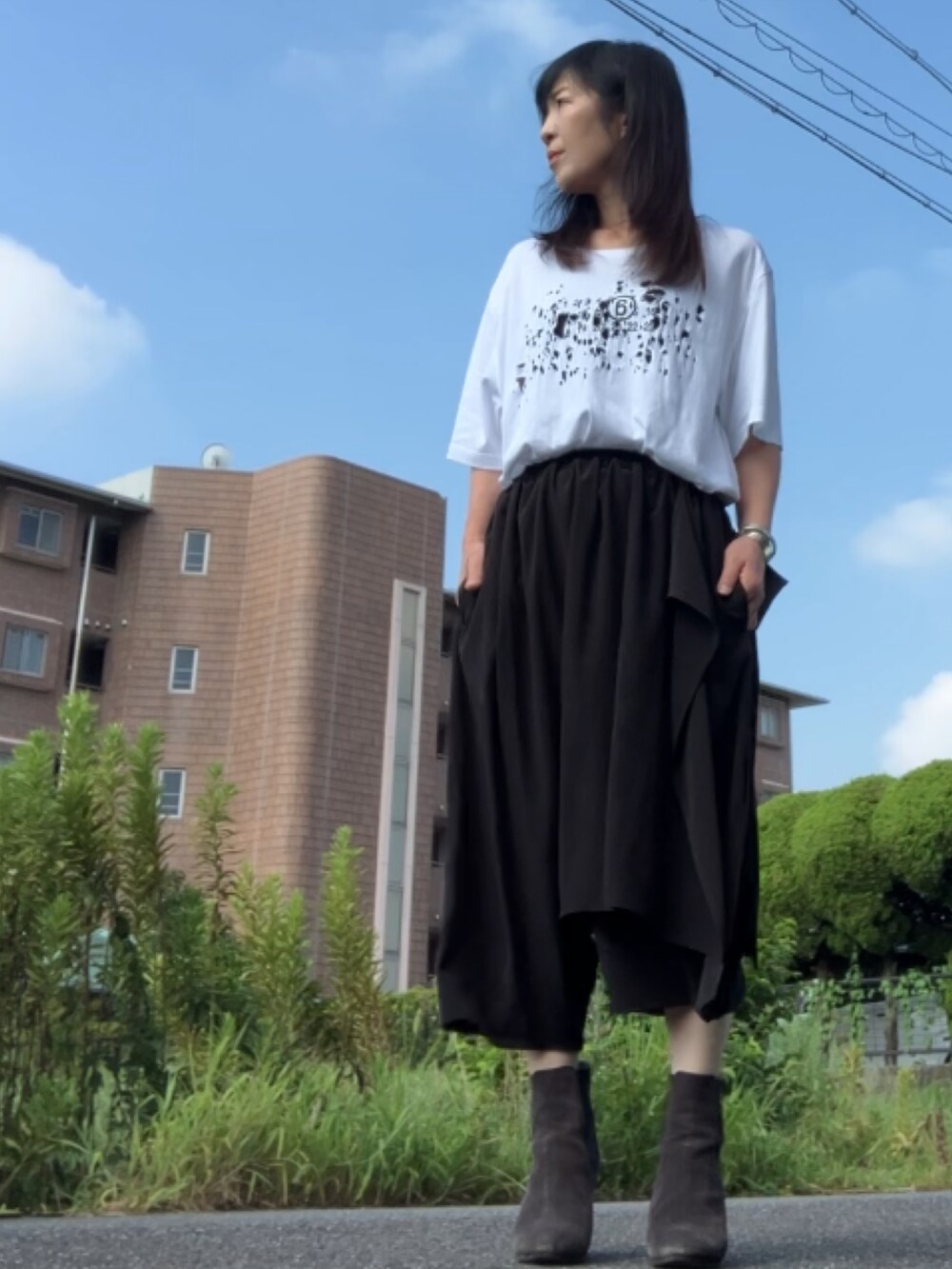 ホワイト系のTシャツ/カットソー、ブラック系のパンツ、グレー系のブーツを着用したレディースの夏コーディネートの2枚目の写真