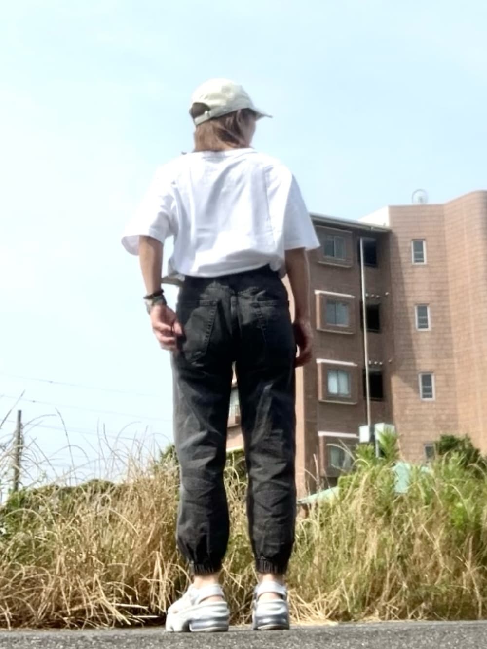 ホワイト系のTシャツ/カットソー、シルバー系のサンダル、ブラック系のデニムパンツを着用したレディースの夏コーディネートの3枚目の写真