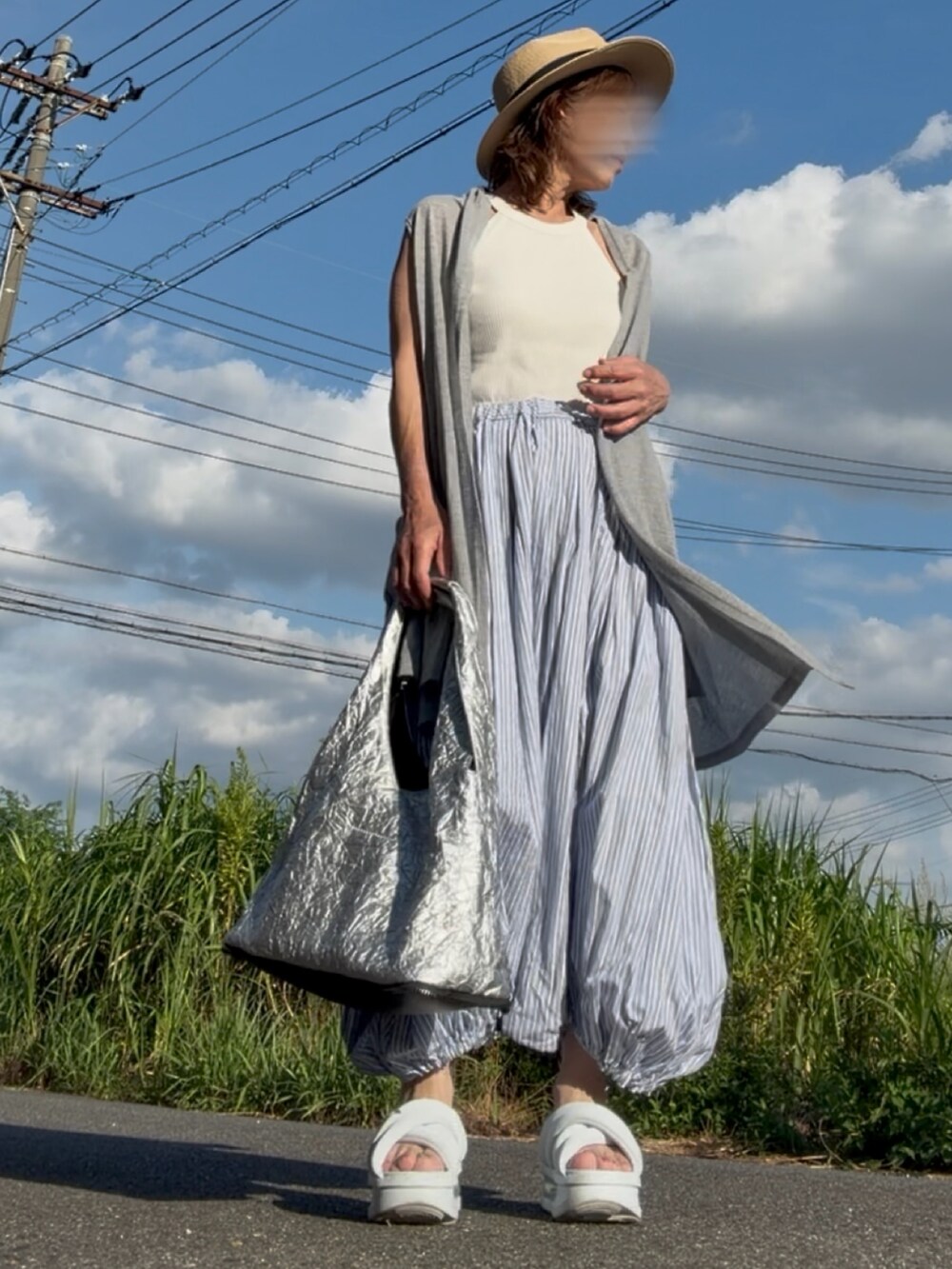ブルー系のサンダル、グレー系のベスト、ブルー系のパンツを着用したレディースの夏コーディネートの3枚目の写真