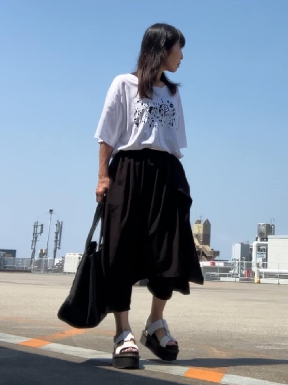 ホワイト系のTシャツ/カットソー、ブラック系のパンツ、グレー系のブーツを着用したレディースの夏コーディネートの4枚目の写真