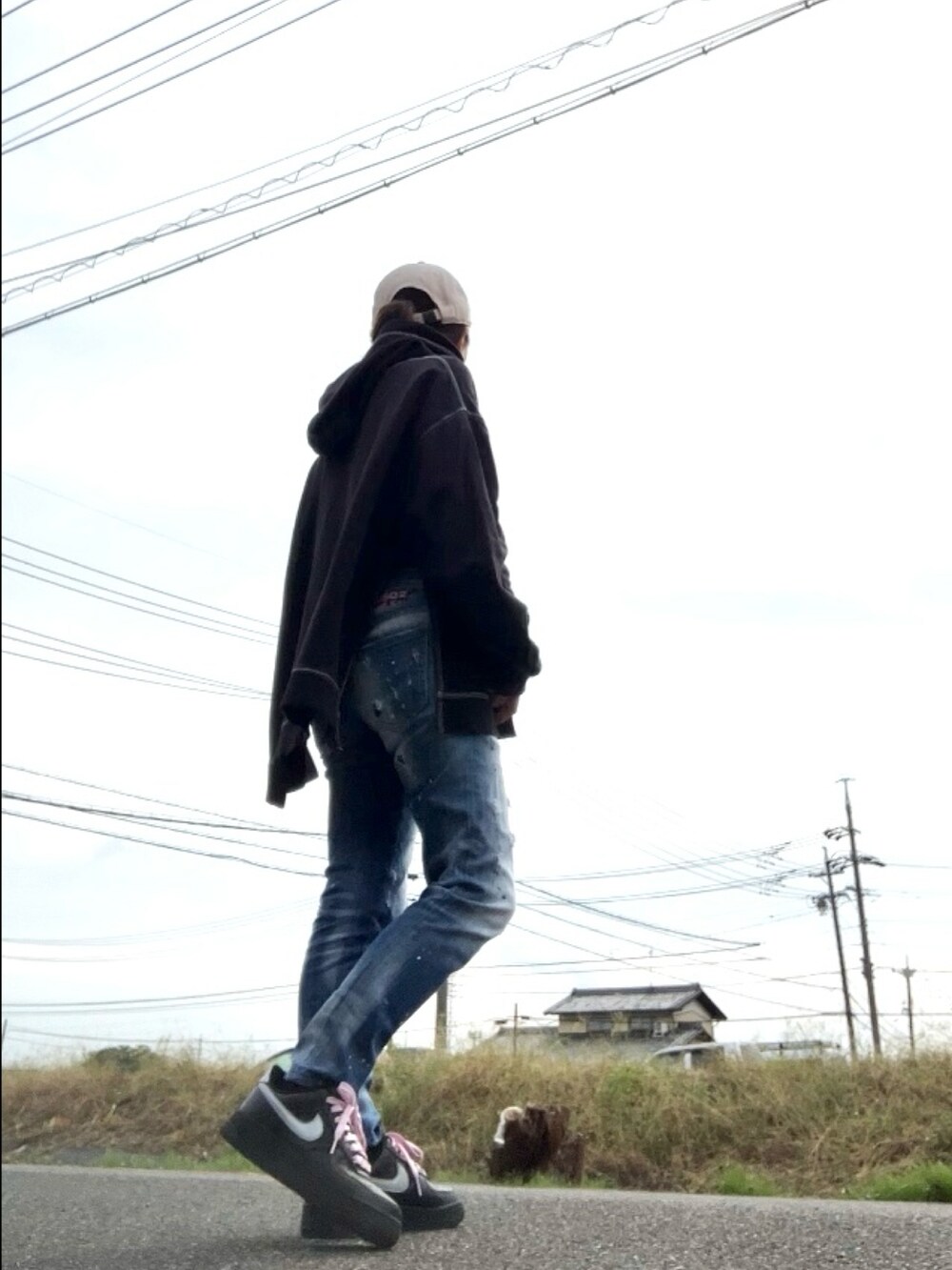 ブラック系のパーカー、ブルー系のデニムパンツ、ブラック系のスニーカーを着用したレディースの秋コーディネートの3枚目の写真