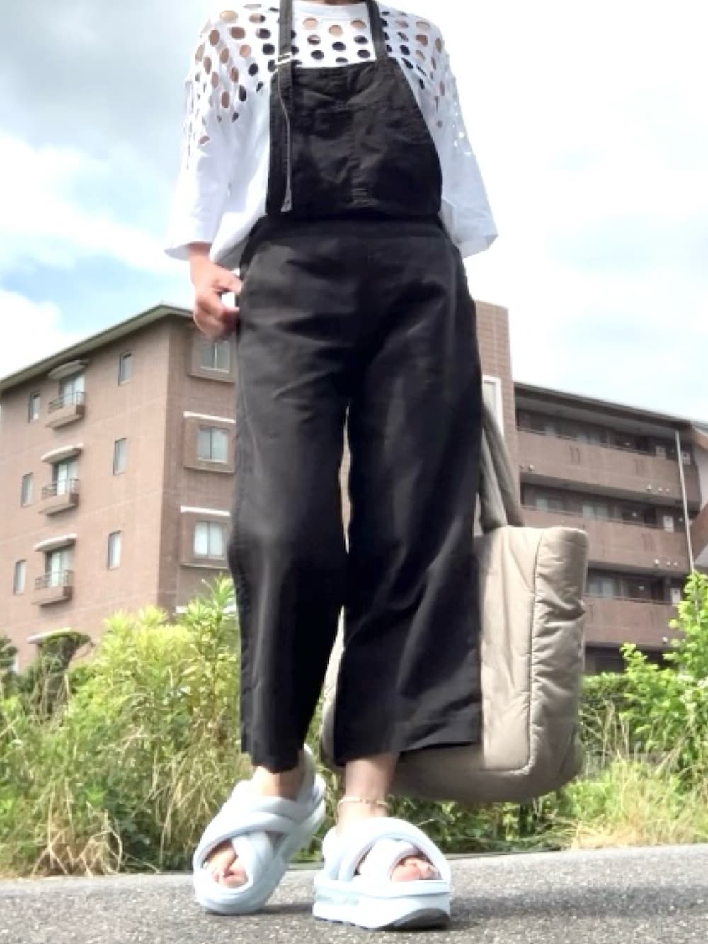 ブルー系のサンダル、ホワイト系のTシャツ/カットソー、ブラック系のサロペット/オーバーオールを着用したレディースの夏コーディネートの4枚目の写真