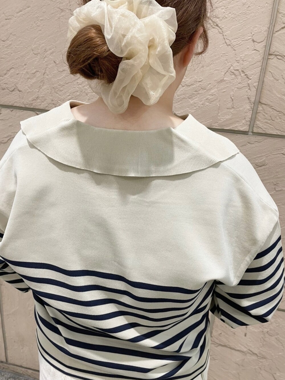 ホワイト系のスカート、ホワイト系のハンドバッグ、ホワイト系のニット/セーターを着用したレディースの秋コーディネートの2枚目の写真