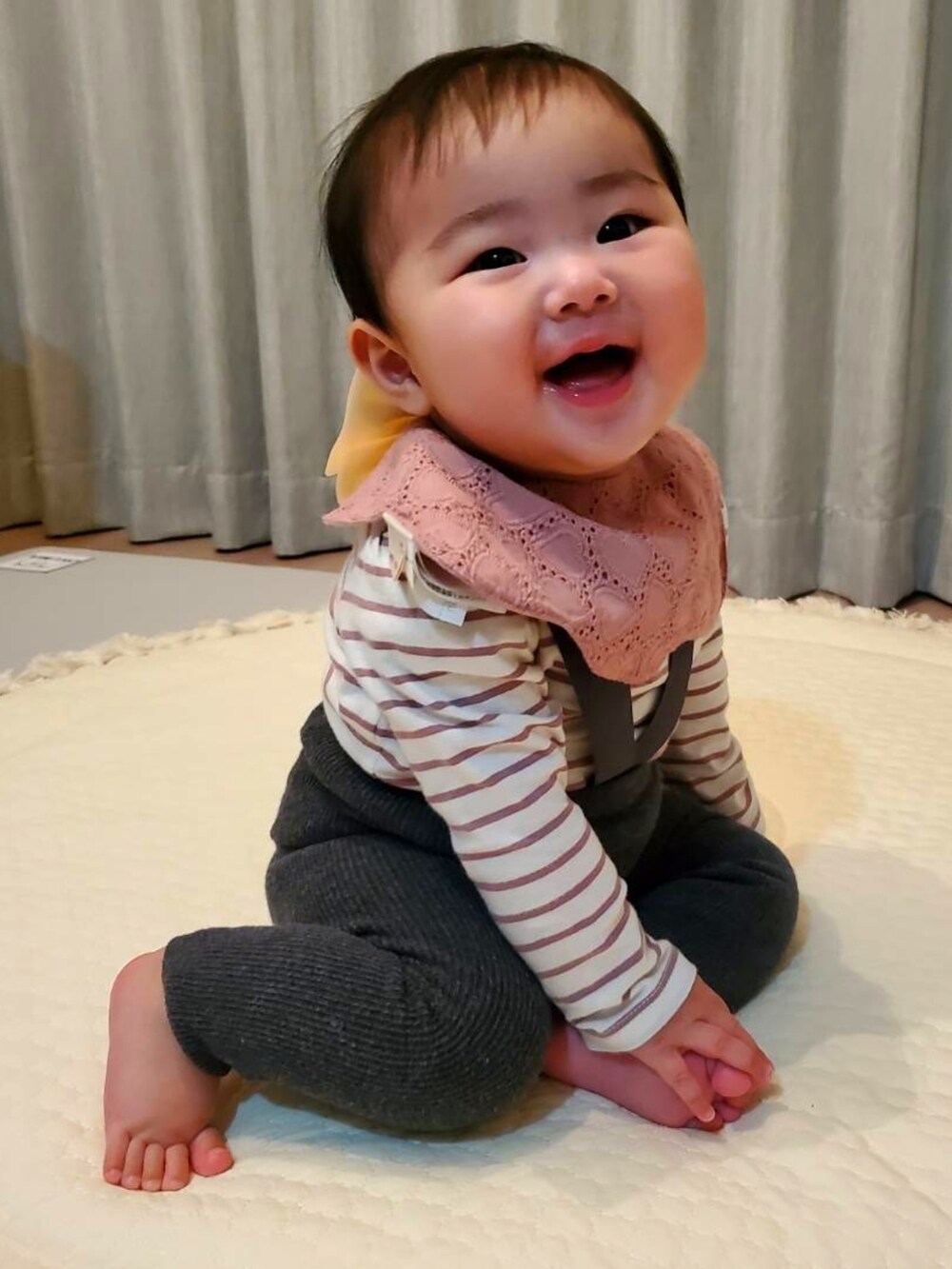 グレー系のパンツ、パープル系のTシャツ/カットソー、ピンク系のスタイ/よだれかけを着用したキッズの春コーディネートの3枚目の写真