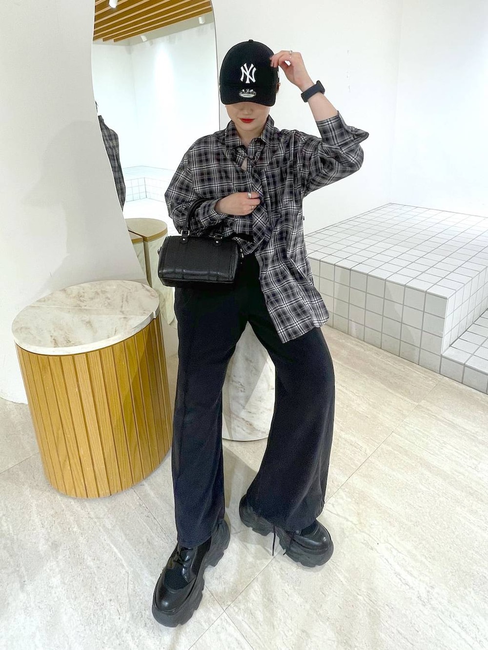 ブラック系のブーツ、ブラック系のスウェットパンツ、ブラック系のショルダーバッグを着用したレディースの冬コーディネートの2枚目の写真