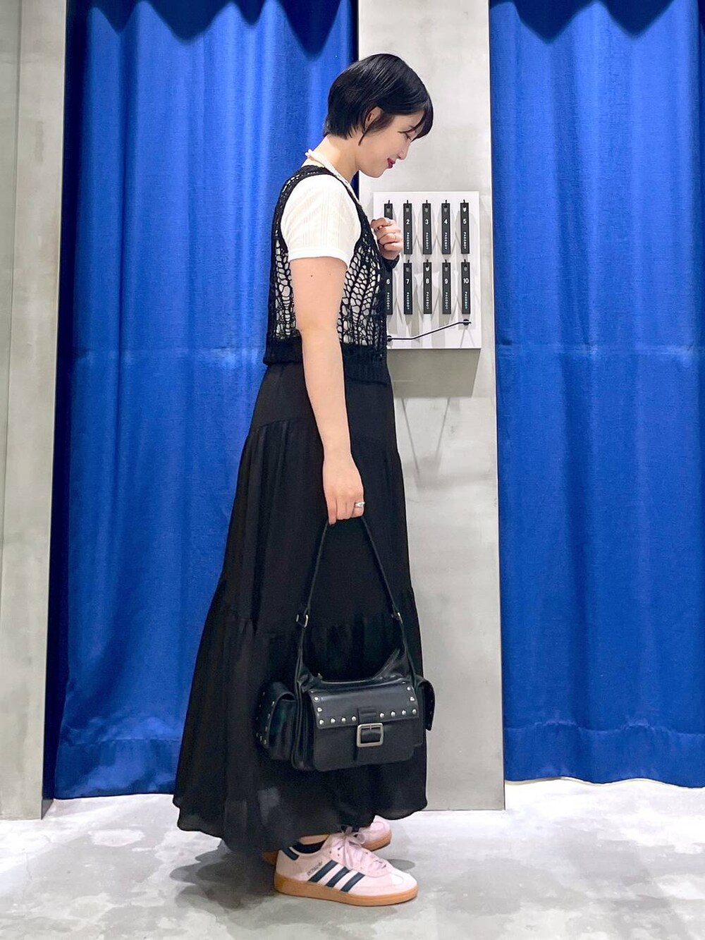 ブラック系のスカート、ブラック系のショルダーバッグ、ブラック系のTシャツ/カットソーを着用したレディースの夏コーディネートの4枚目の写真