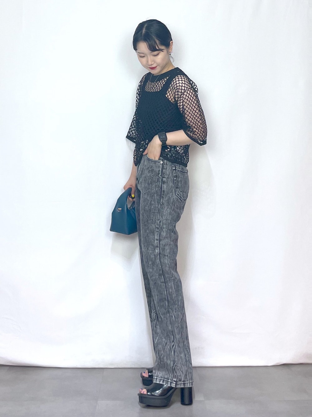 ブラック系のTシャツ/カットソー、ブラック系のタンクトップ、ブルー系のショルダーバッグを着用したレディースの夏コーディネートの2枚目の写真