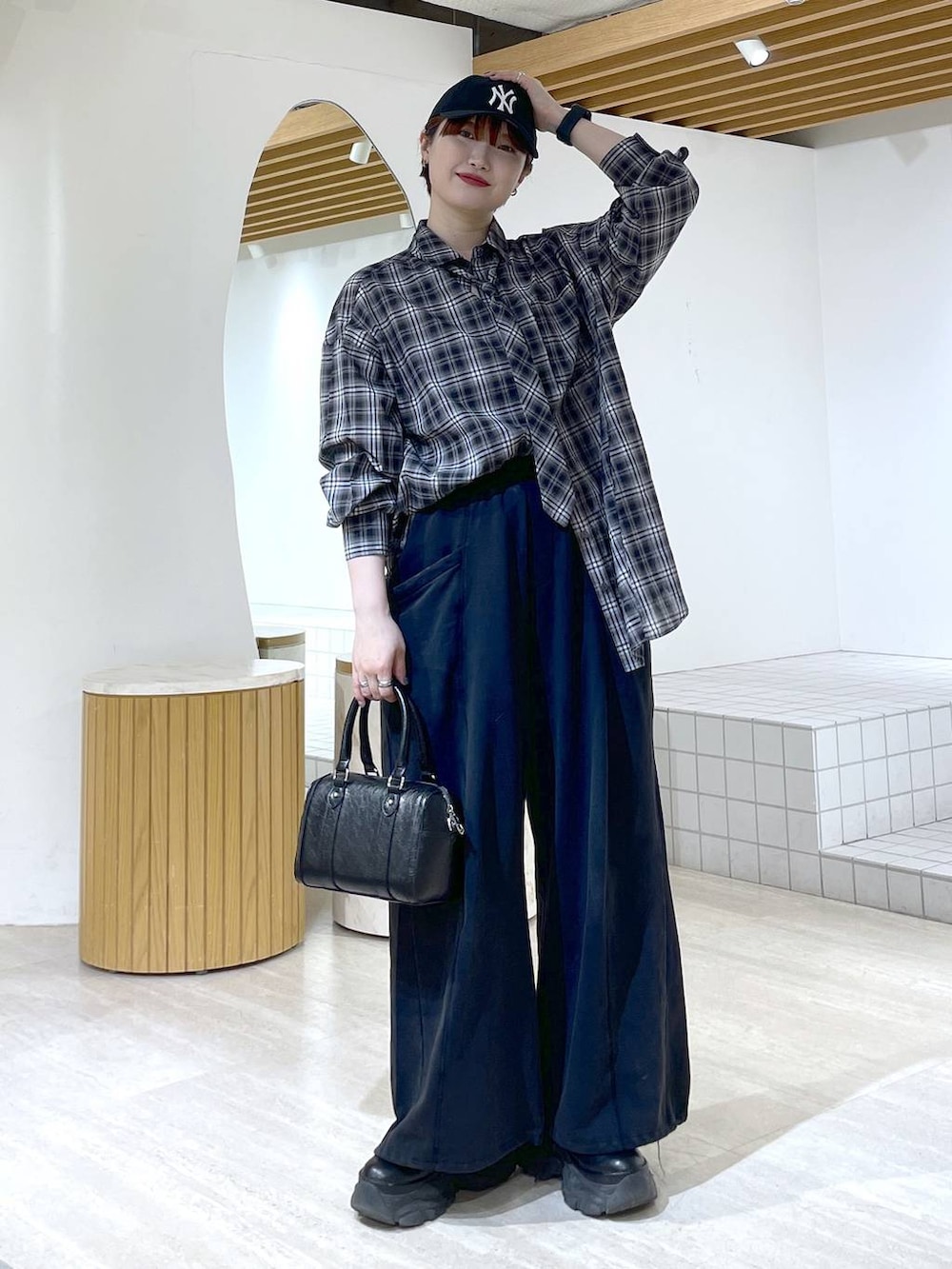 ブラック系のブーツ、ブラック系のスウェットパンツ、ブラック系のショルダーバッグを着用したレディースの冬コーディネートの5枚目の写真