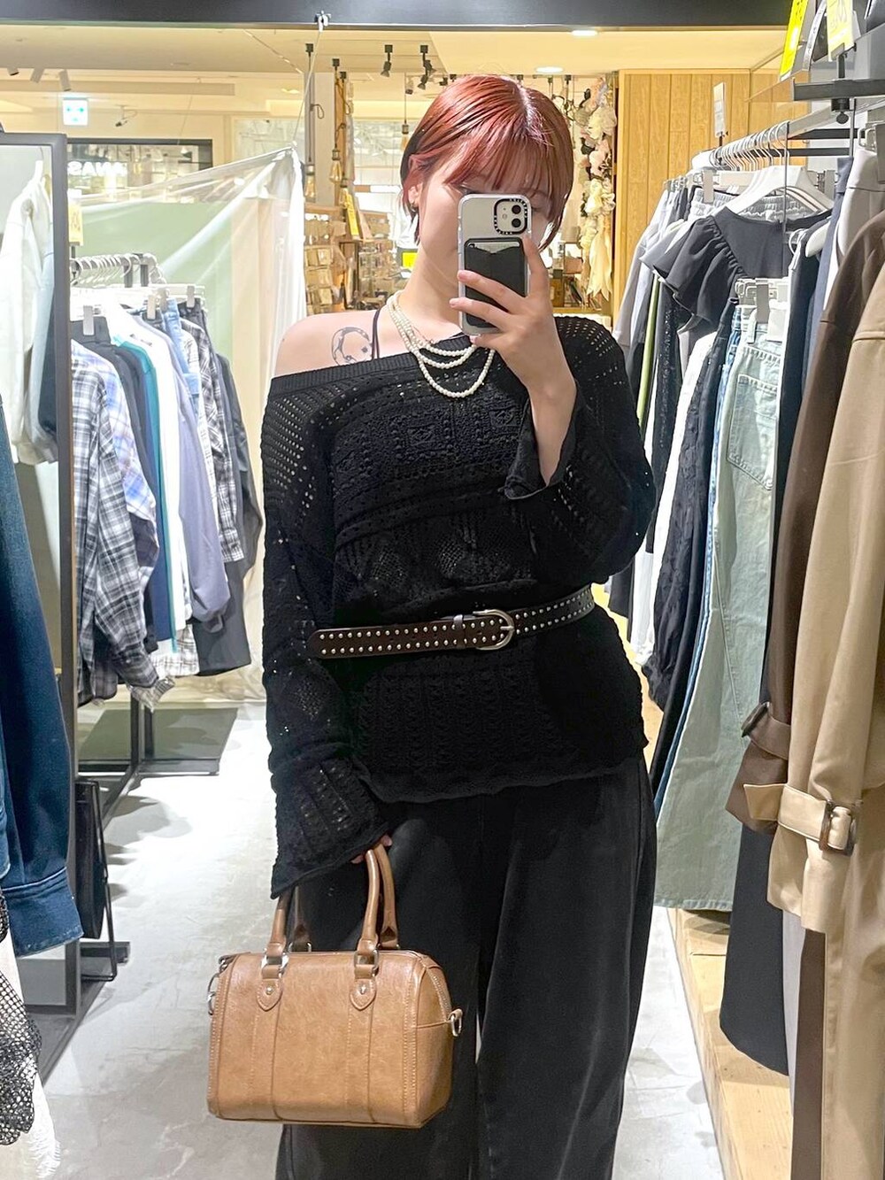 ブラック系のブーツ、ブラウン系のボストンバッグ、ブラック系のデニムパンツを着用したレディースの春コーディネートの3枚目の写真