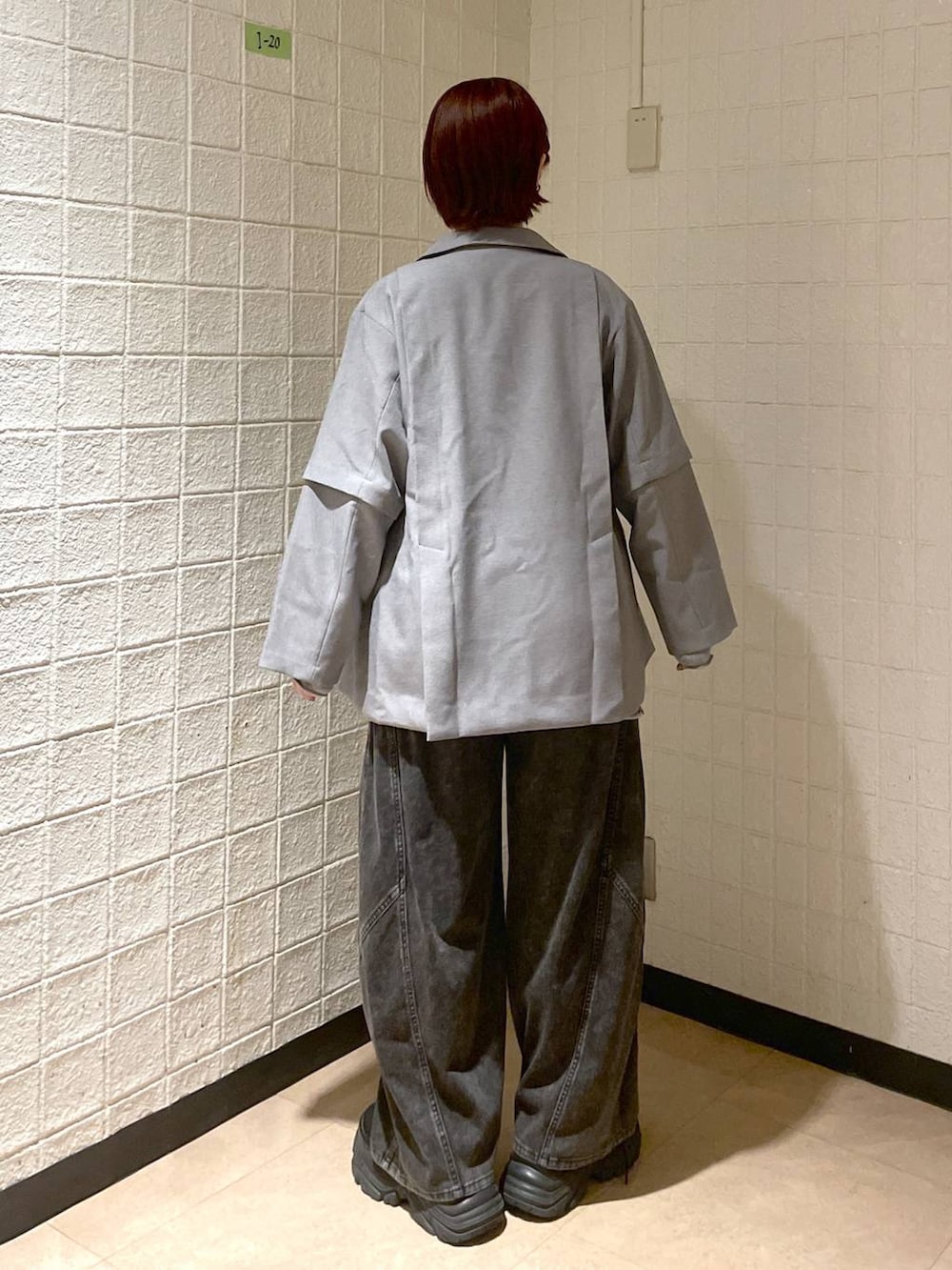 ブラック系のブーツ、グレー系のテーラードジャケット、ブラック系のデニムパンツを着用したレディースの春コーディネートの5枚目の写真