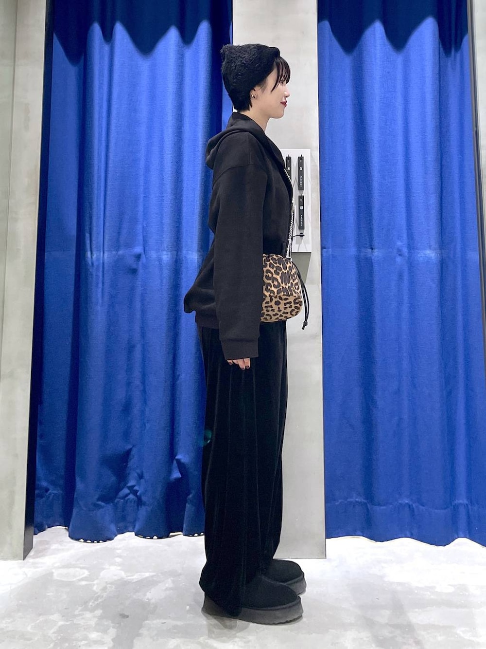 ブラック系のパーカー、ブラック系のその他パンツ、その他のハンドバッグを着用したレディースの冬コーディネートの3枚目の写真