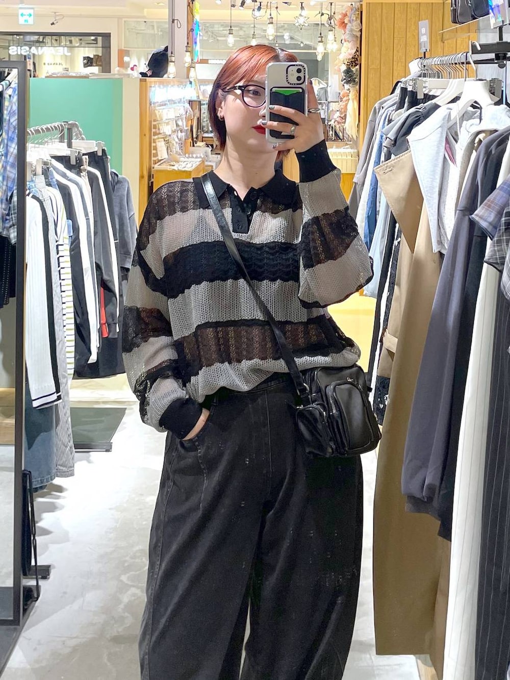 ブラック系のブーツ、ブラック系のデニムパンツ、ブラック系のショルダーバッグを着用したレディースの春コーディネートの3枚目の写真