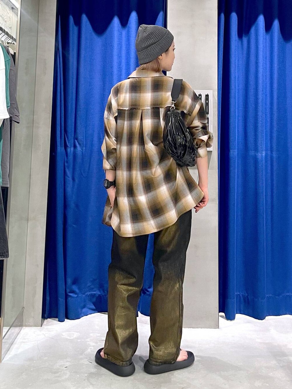 ブラック系のデニムパンツ、ブラック系のショルダーバッグ、イエロー系のシャツ/ブラウスを着用したレディースの秋コーディネートの3枚目の写真