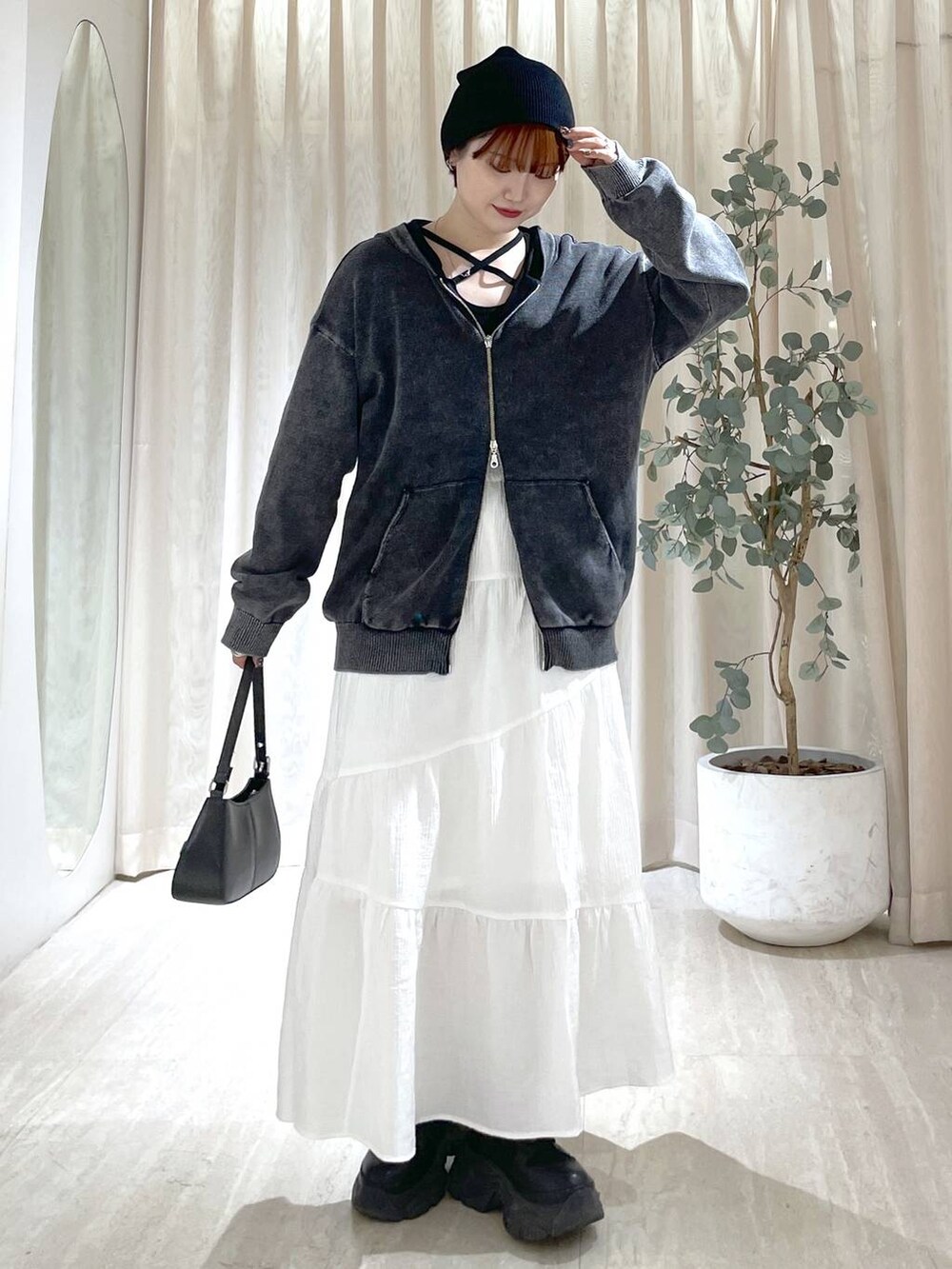 ブラック系のブーツ、ブラック系のハンドバッグ、ブラック系のニット/セーターを着用したレディースの冬コーディネートの2枚目の写真