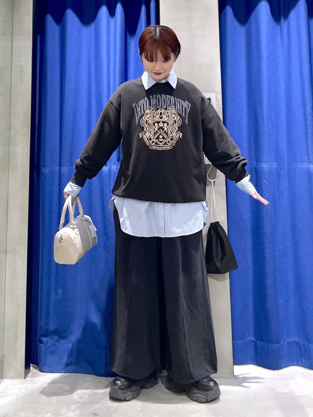 ブラック系のブーツ、ホワイト系のボストンバッグ、グレー系のスウェットを着用したレディースの冬コーディネートの3枚目の写真