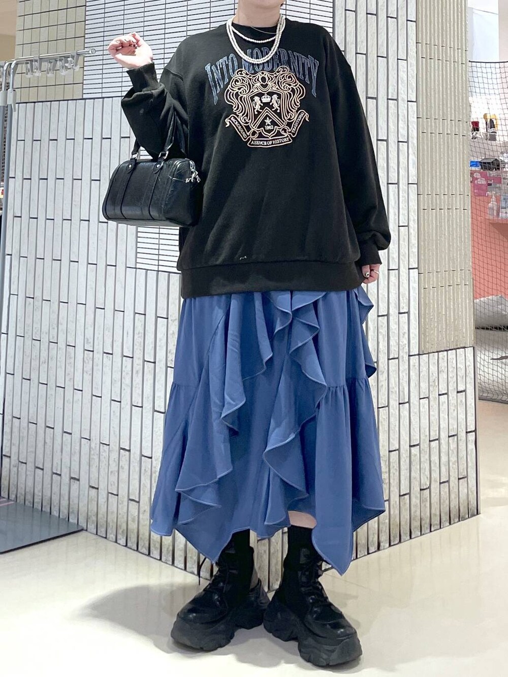 ブラック系のブーツ、ブルー系のスカート、グレー系のスウェットを着用したレディースの冬コーディネートの2枚目の写真