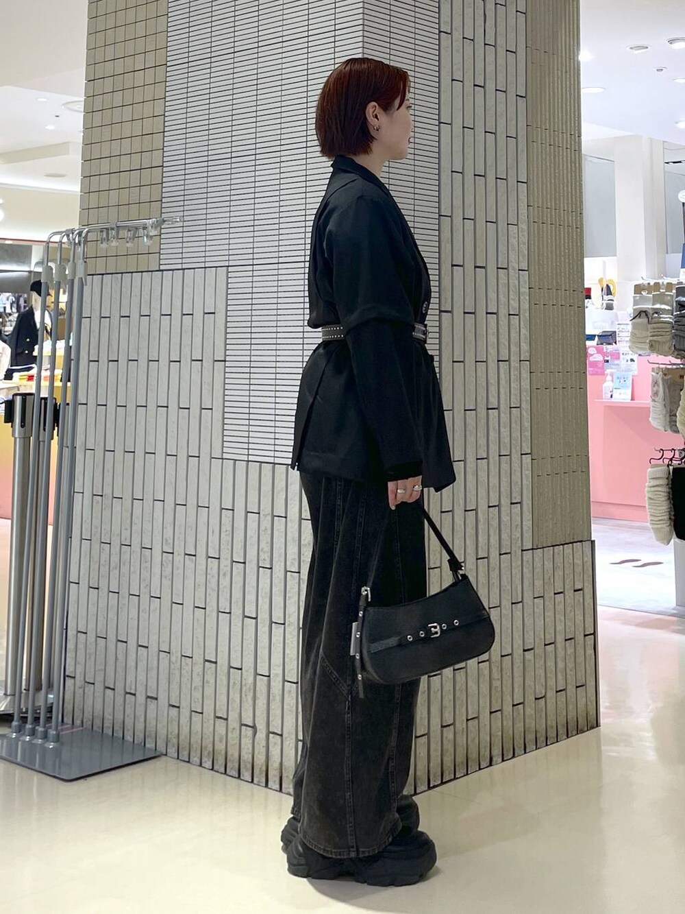 ブラック系のブーツ、ブラック系のハンドバッグ、ブラック系のテーラードジャケットを着用したレディースの春コーディネートの4枚目の写真