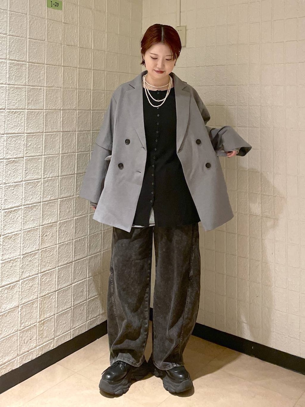 ブラック系のブーツ、グレー系のテーラードジャケット、ブラック系のデニムパンツを着用したレディースの春コーディネートの2枚目の写真