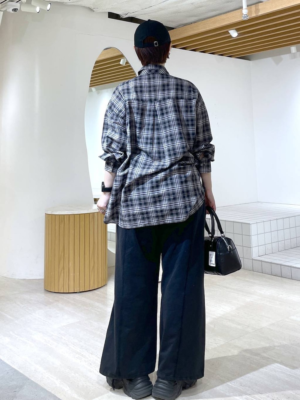 ブラック系のブーツ、ブラック系のスウェットパンツ、ブラック系のショルダーバッグを着用したレディースの冬コーディネートの7枚目の写真