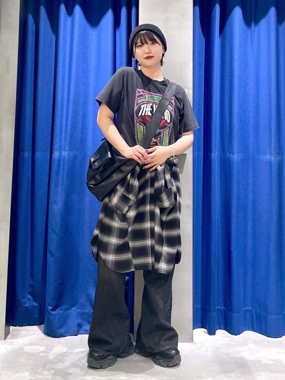 ブラック系のスニーカー、ブラック系のデニムパンツ、ブラック系のショルダーバッグを着用したレディースの秋コーディネートの3枚目の写真
