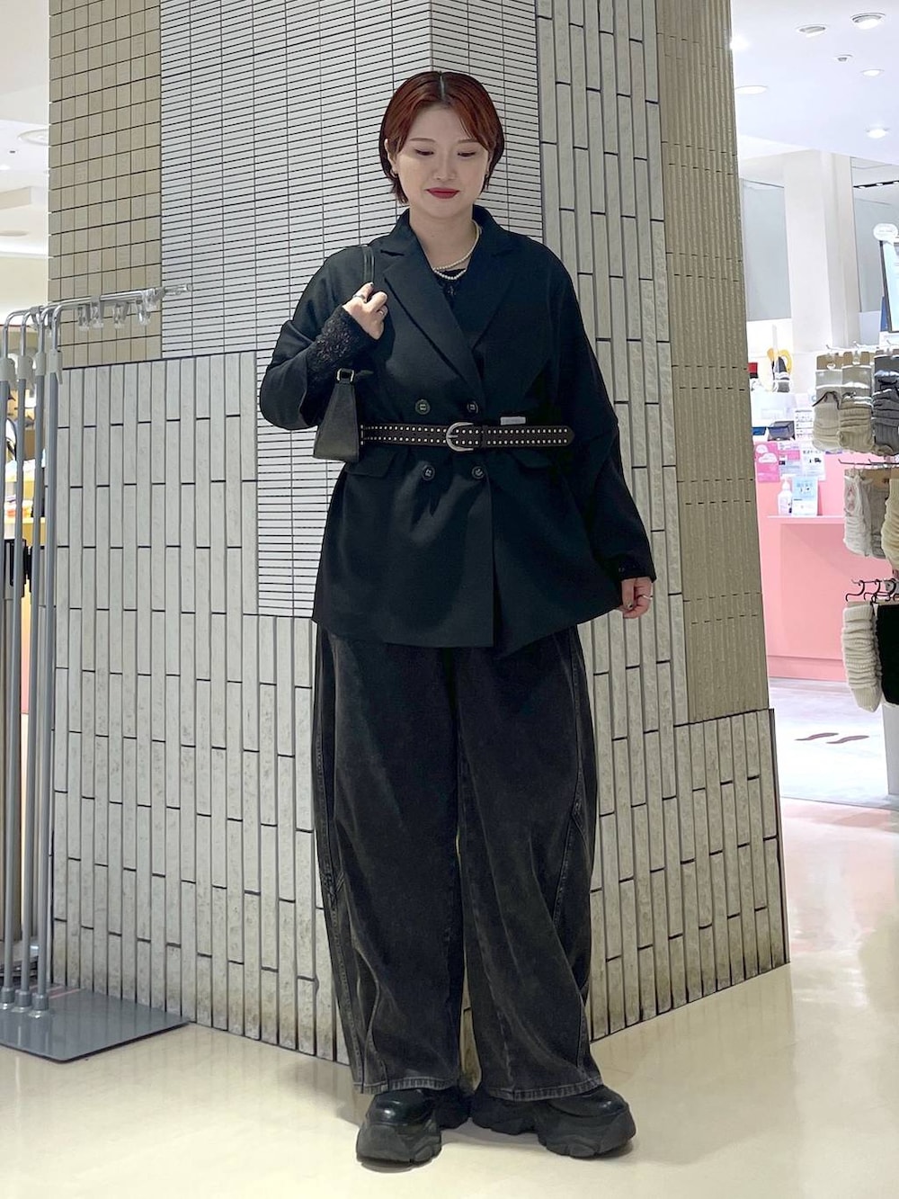 ブラック系のブーツ、ブラック系のハンドバッグ、ブラック系のテーラードジャケットを着用したレディースの春コーディネートの2枚目の写真