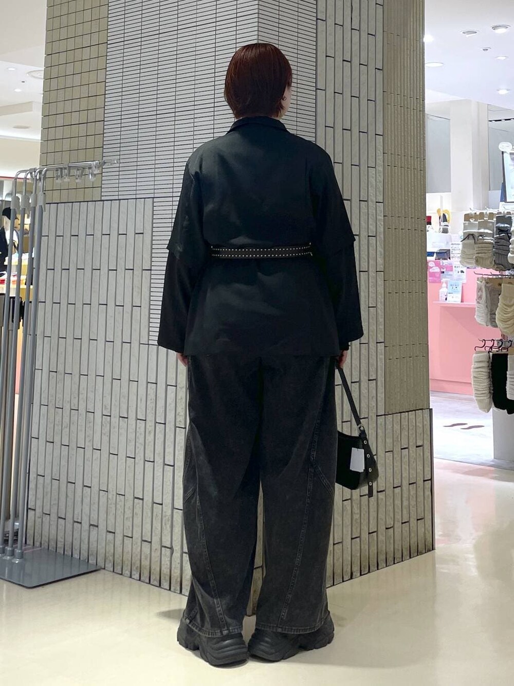 ブラック系のブーツ、ブラック系のハンドバッグ、ブラック系のテーラードジャケットを着用したレディースの春コーディネートの5枚目の写真