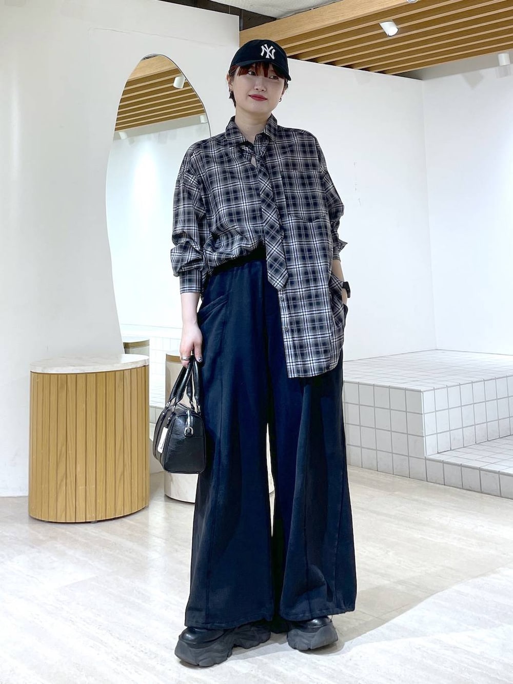 ブラック系のブーツ、ブラック系のスウェットパンツ、ブラック系のショルダーバッグを着用したレディースの冬コーディネートの3枚目の写真