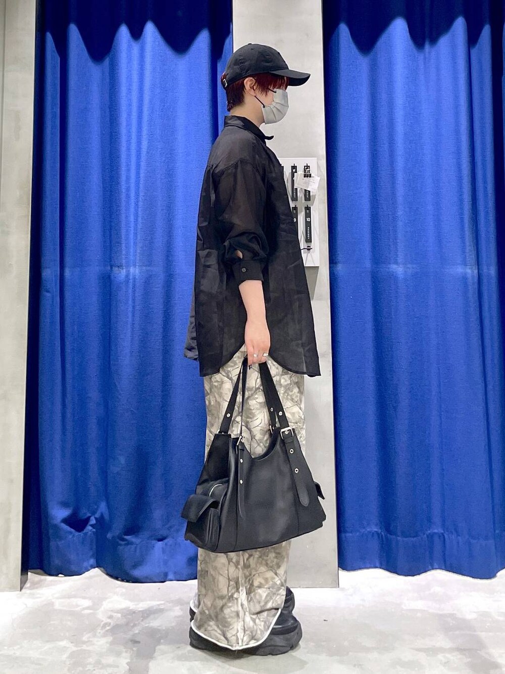 ブラック系のブーツ、ブラック系のシャツ/ブラウス、ブラック系のハンドバッグを着用したレディースの春コーディネートの3枚目の写真