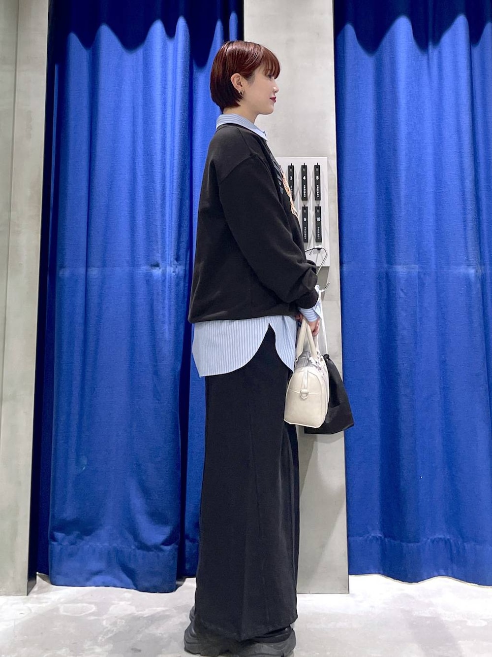 ブラック系のブーツ、ホワイト系のボストンバッグ、グレー系のスウェットを着用したレディースの冬コーディネートの4枚目の写真