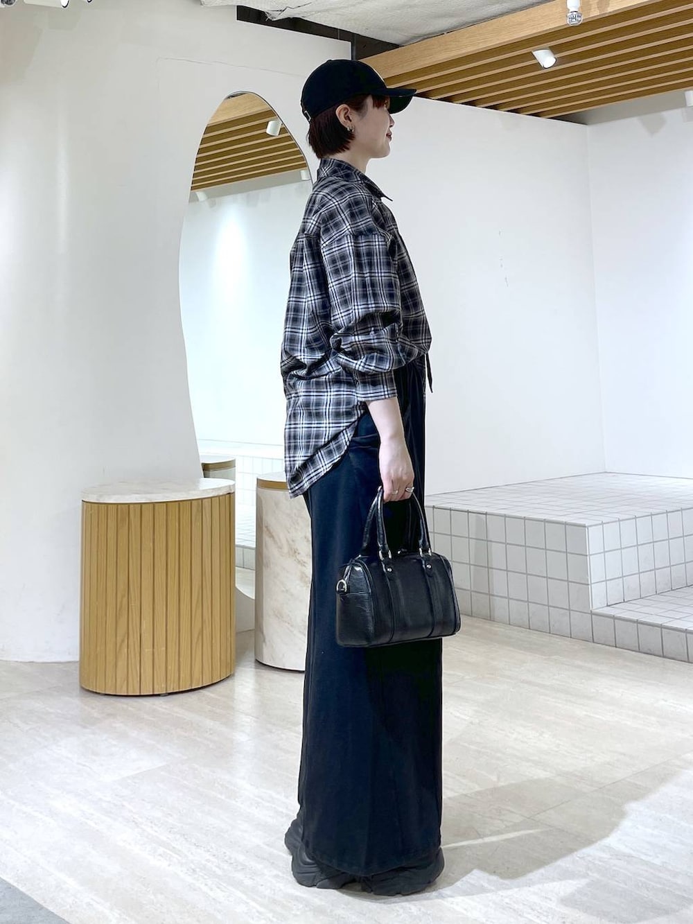 ブラック系のブーツ、ブラック系のスウェットパンツ、ブラック系のショルダーバッグを着用したレディースの冬コーディネートの6枚目の写真