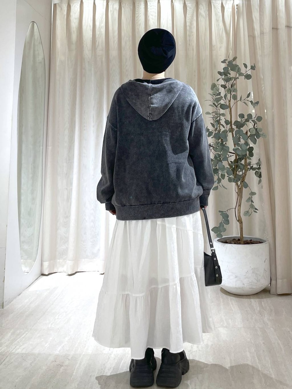 ブラック系のブーツ、ブラック系のハンドバッグ、ブラック系のニット/セーターを着用したレディースの冬コーディネートの5枚目の写真