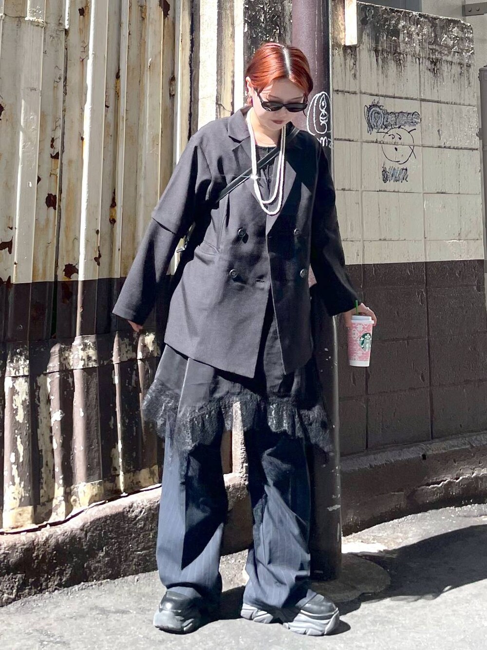 ブラック系のブーツ、ブラック系のチュニック、ブラック系のテーラードジャケットを着用したレディースの春コーディネートの2枚目の写真