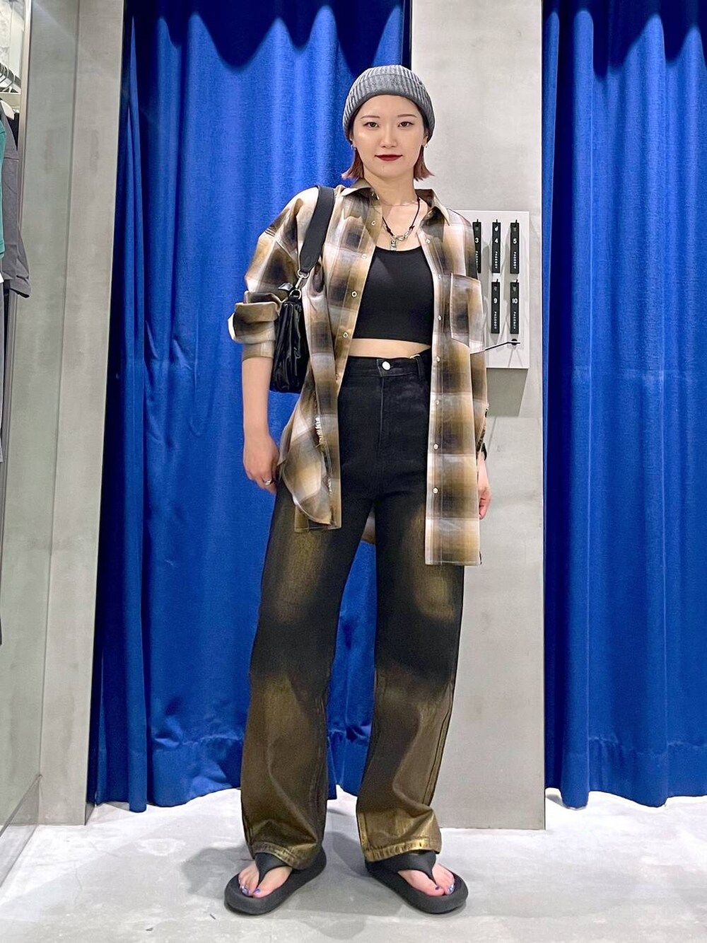 ブラック系のデニムパンツ、ブラック系のショルダーバッグ、イエロー系のシャツ/ブラウスを着用したレディースの秋コーディネートの2枚目の写真