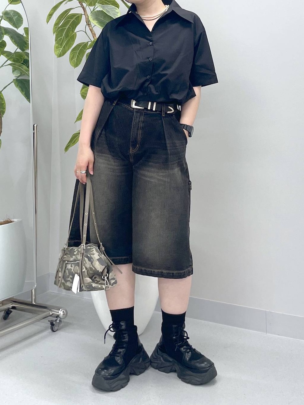 ブラック系のブーツ、ブラック系のデニムパンツ、ブラック系のシャツ/ブラウスを着用したレディースの春コーディネートの2枚目の写真