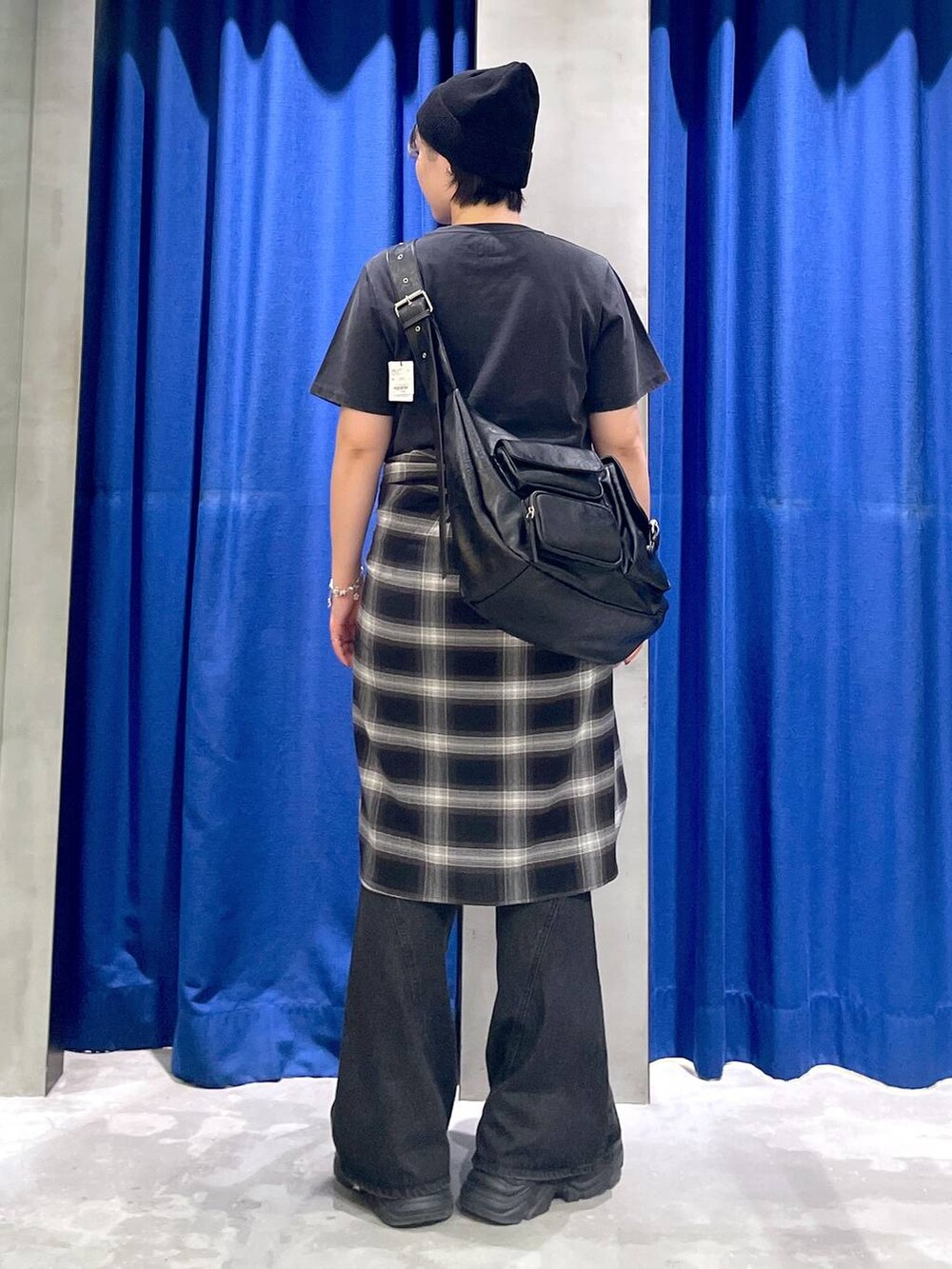 ブラック系のスニーカー、ブラック系のデニムパンツ、ブラック系のショルダーバッグを着用したレディースの秋コーディネートの5枚目の写真