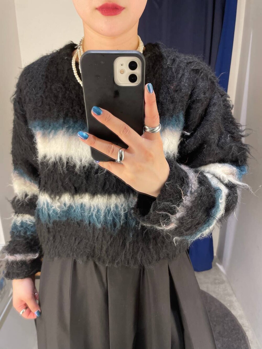 ブラック系のブーツ、ブラック系のスカート、ブラック系のショルダーバッグを着用したレディースの冬コーディネートの5枚目の写真