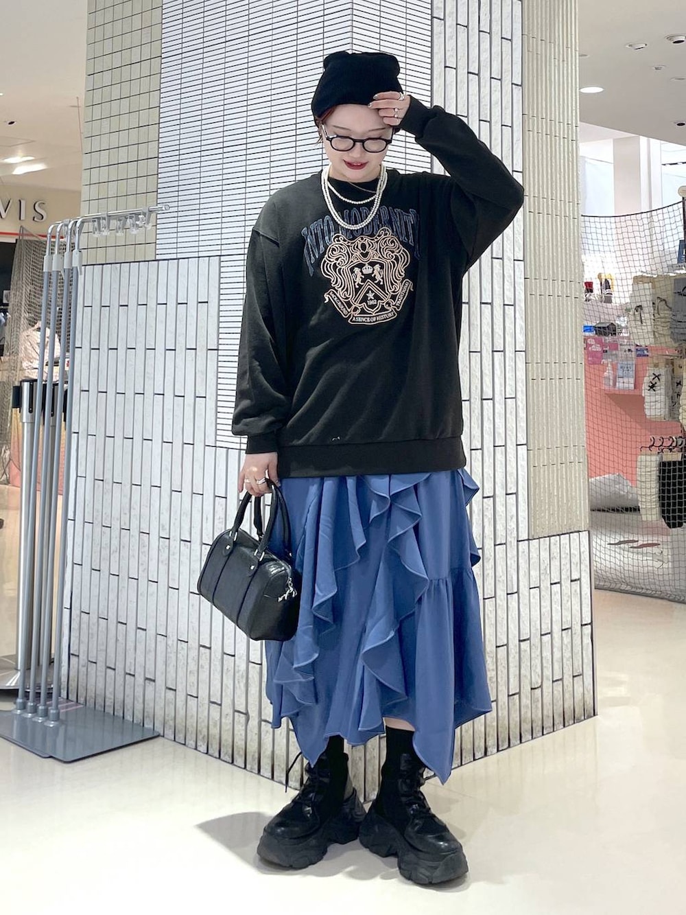 ブラック系のブーツ、ブルー系のスカート、グレー系のスウェットを着用したレディースの冬コーディネートの3枚目の写真