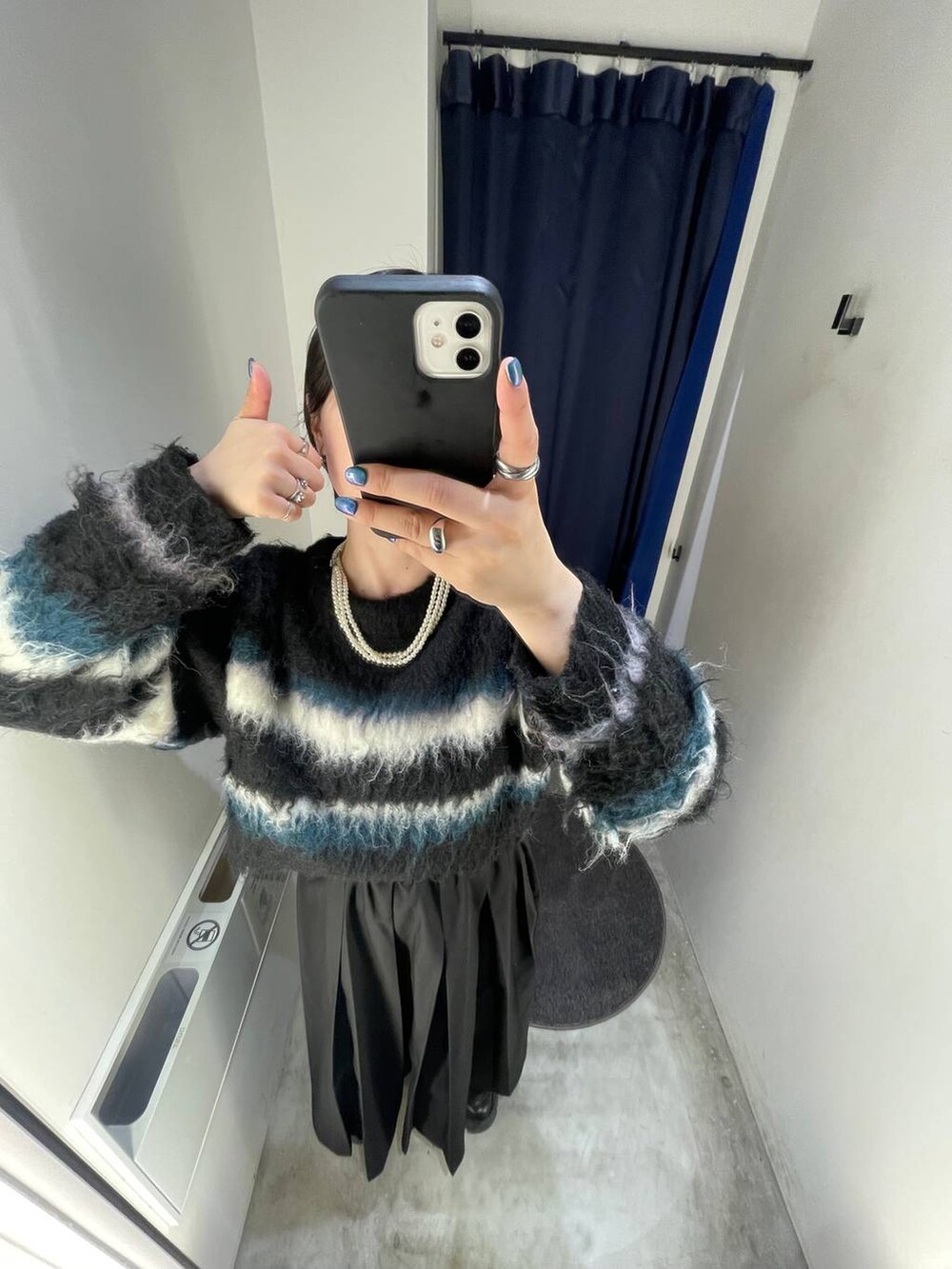 ブラック系のブーツ、ブラック系のスカート、ブラック系のショルダーバッグを着用したレディースの冬コーディネートの6枚目の写真