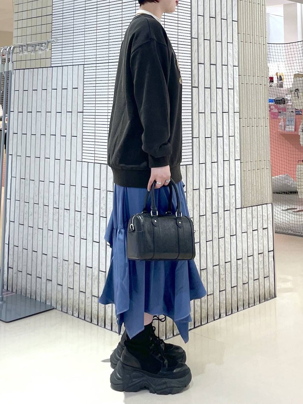 ブラック系のブーツ、ブルー系のスカート、グレー系のスウェットを着用したレディースの冬コーディネートの4枚目の写真