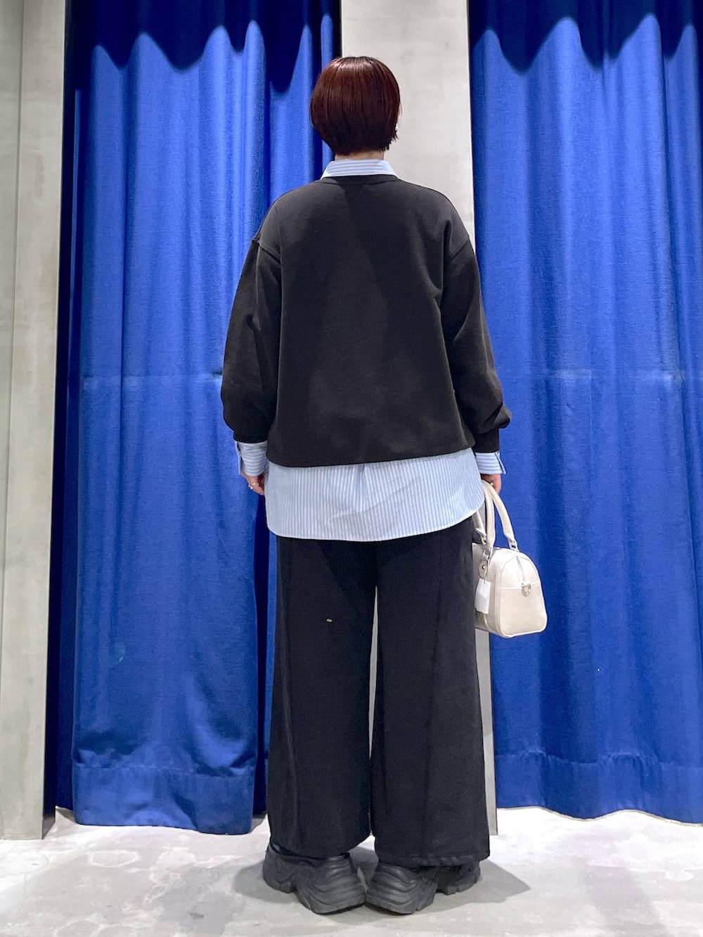 ブラック系のブーツ、ホワイト系のボストンバッグ、グレー系のスウェットを着用したレディースの冬コーディネートの5枚目の写真