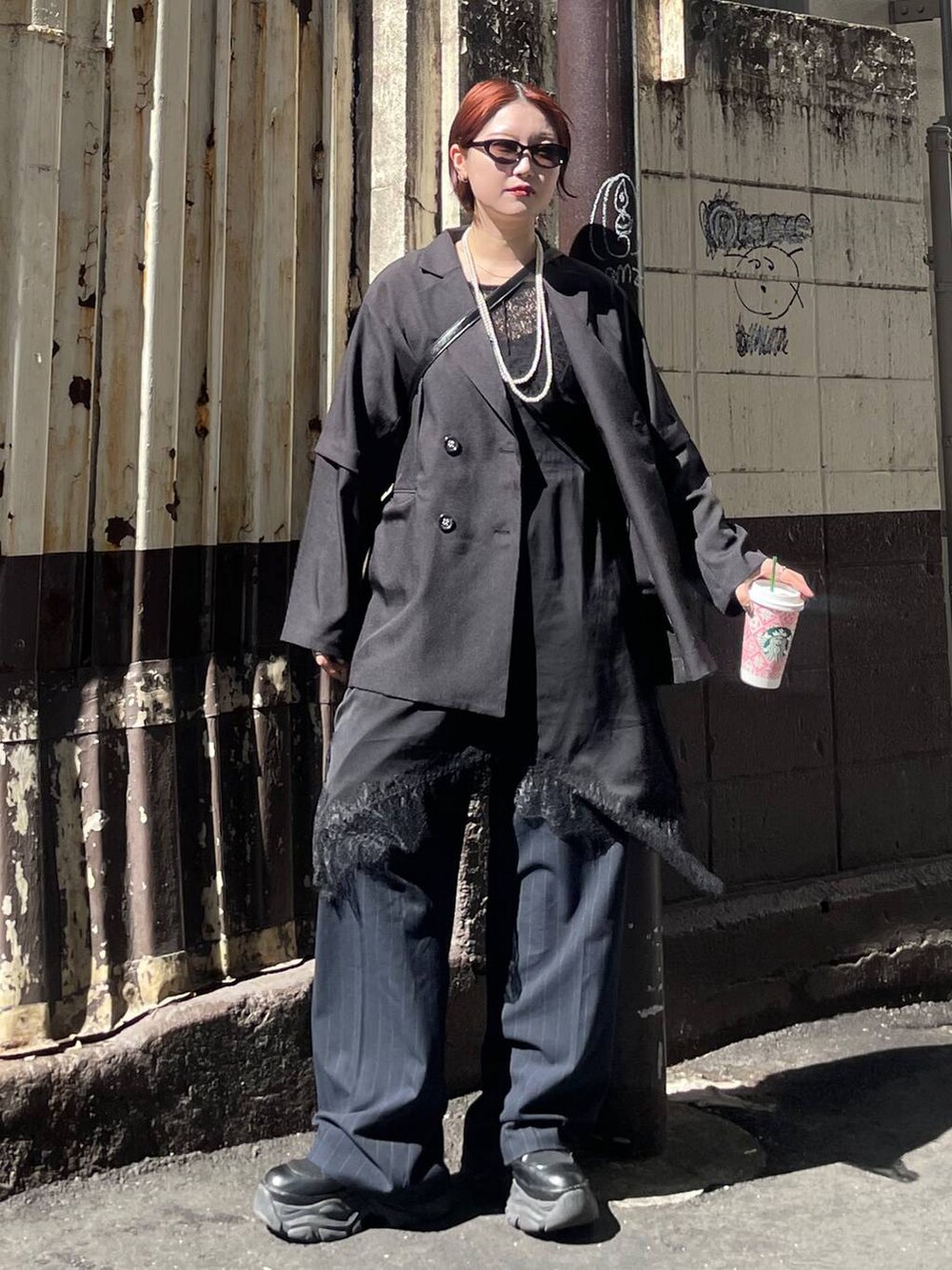 ブラック系のブーツ、ブラック系のチュニック、ブラック系のテーラードジャケットを着用したレディースの春コーディネートの3枚目の写真