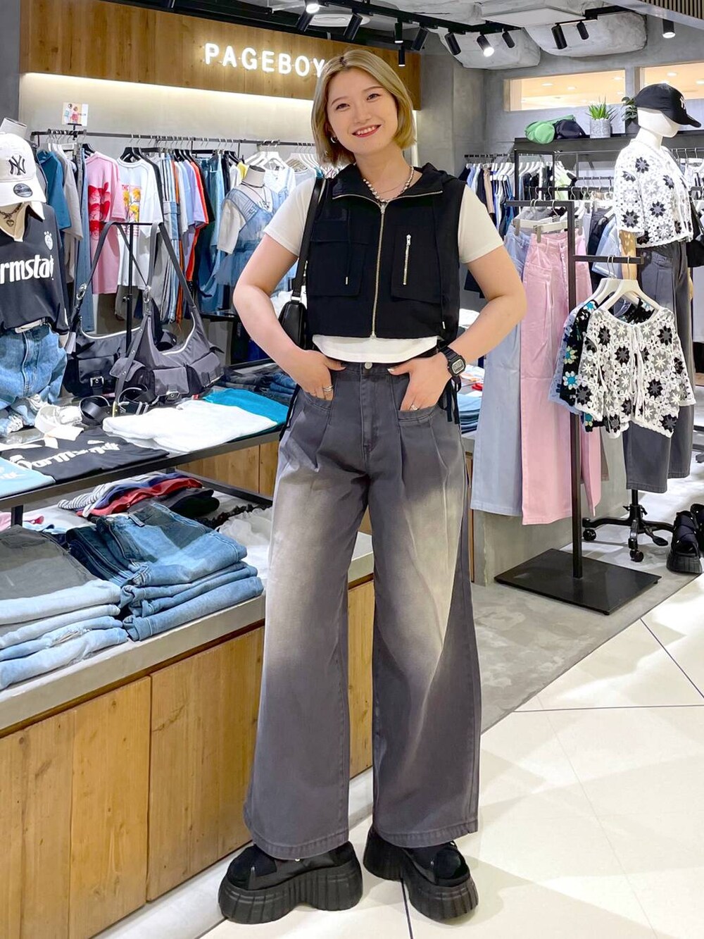 ブラック系のスニーカー、ブラック系のハンドバッグ、ホワイト系のTシャツ/カットソーを着用したレディースの夏コーディネートの3枚目の写真