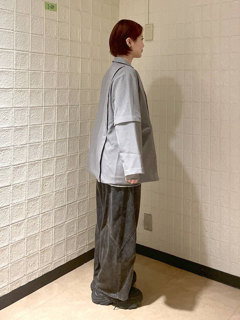 ブラック系のブーツ、グレー系のテーラードジャケット、ブラック系のデニムパンツを着用したレディースの春コーディネートの4枚目の写真