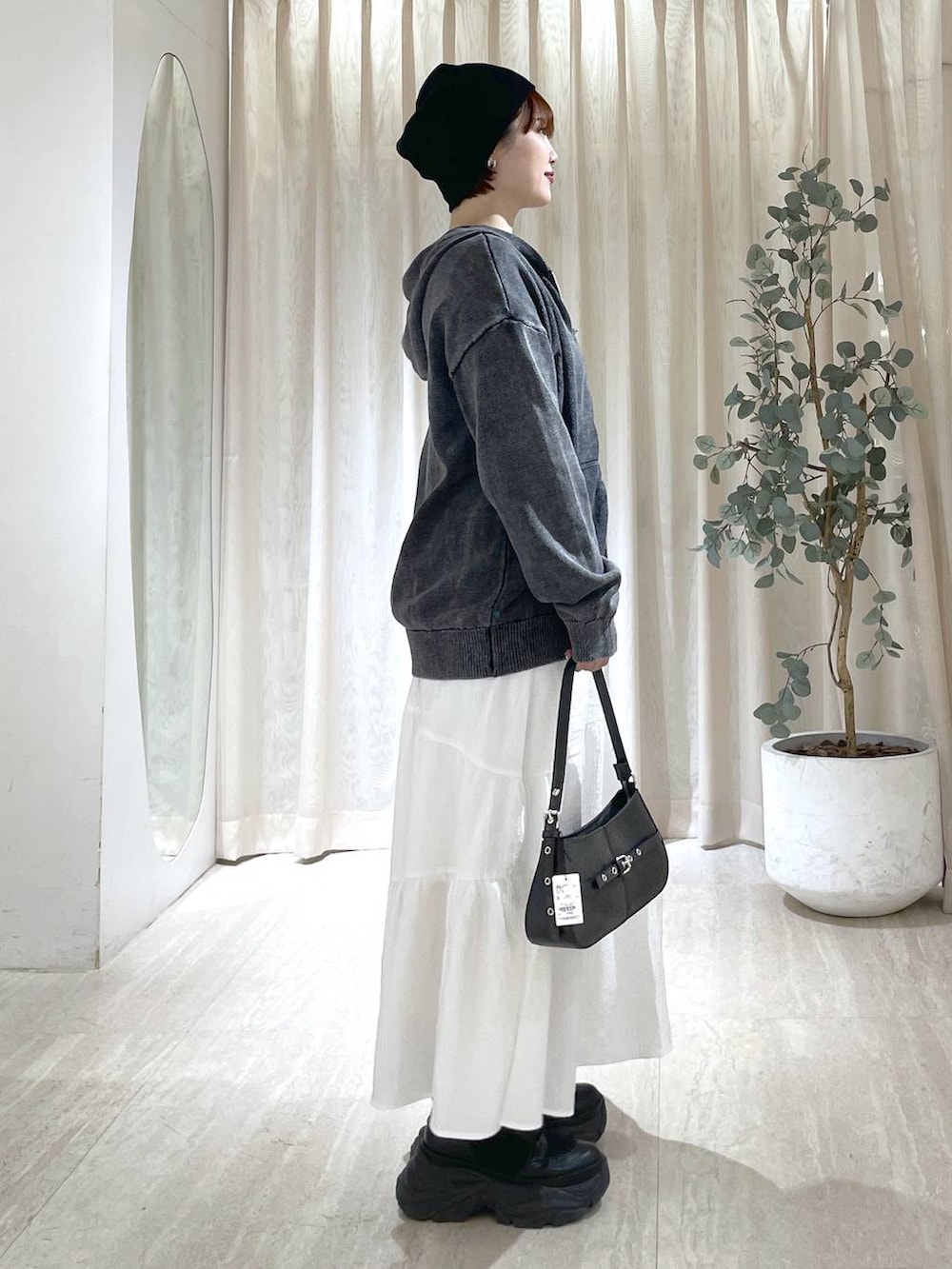 ブラック系のブーツ、ブラック系のハンドバッグ、ブラック系のニット/セーターを着用したレディースの冬コーディネートの4枚目の写真