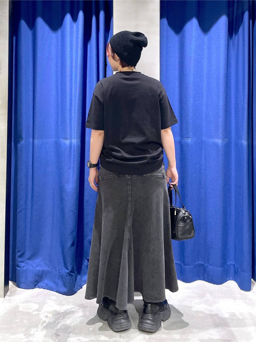 ブラック系のショルダーバッグ、ブラック系のブーツ、ブラック系のデニムスカートを着用したレディースの夏コーディネートの3枚目の写真