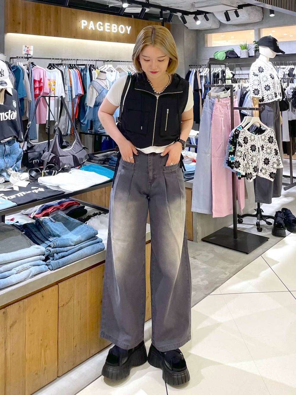 ブラック系のスニーカー、ブラック系のハンドバッグ、ホワイト系のTシャツ/カットソーを着用したレディースの夏コーディネートの2枚目の写真