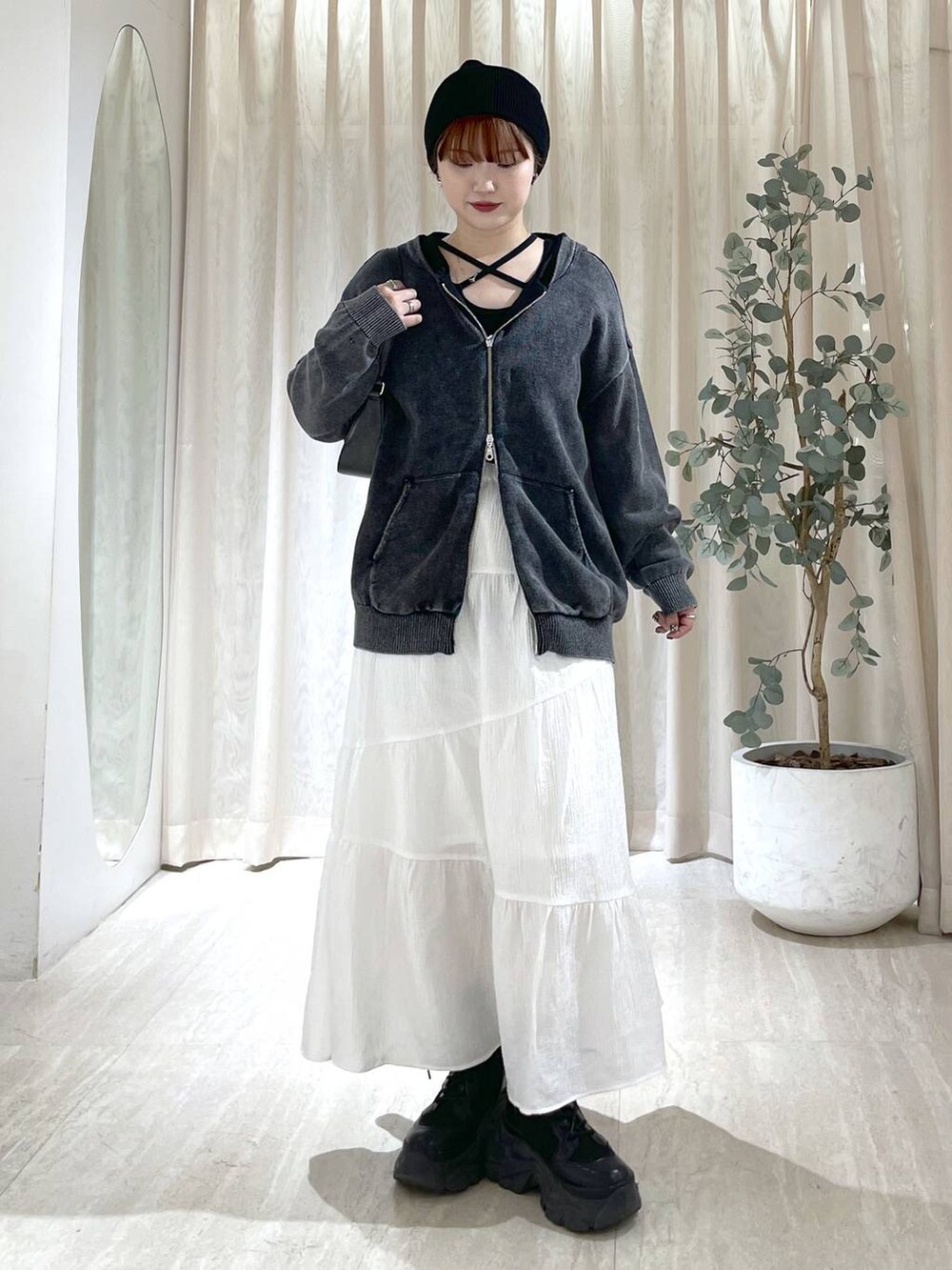 ブラック系のブーツ、ブラック系のハンドバッグ、ブラック系のニット/セーターを着用したレディースの冬コーディネートの3枚目の写真