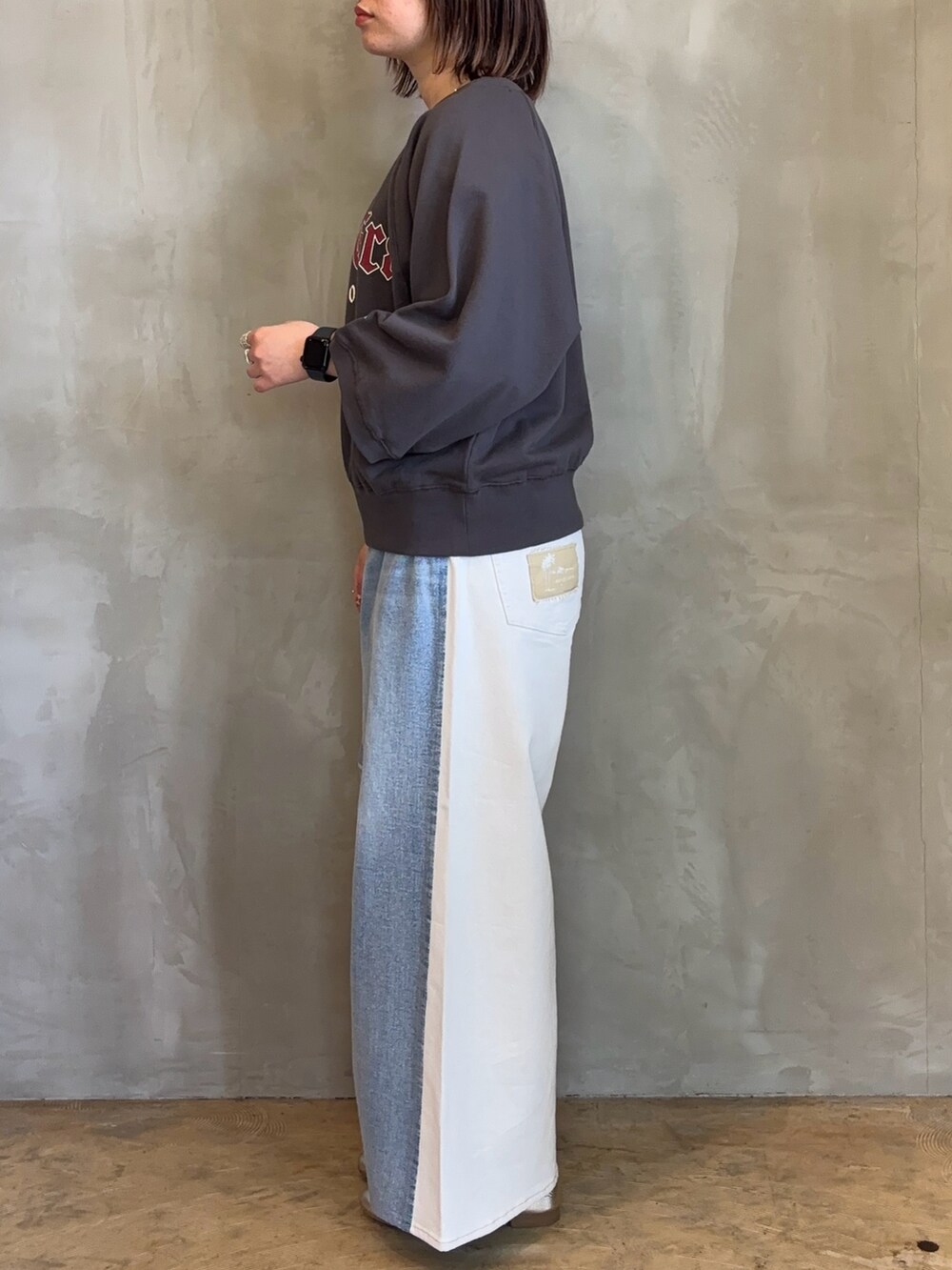 グレー系のトップス、ブルー系のデニムパンツを着用したレディースの春コーディネートの2枚目の写真